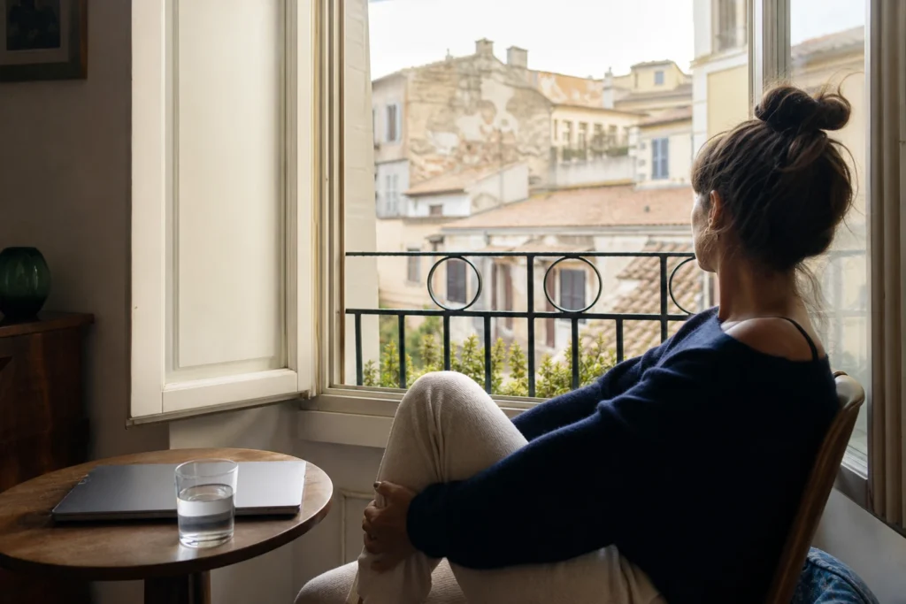 Persona che fa una pausa vicino alla finestra per recuperare energia mentale