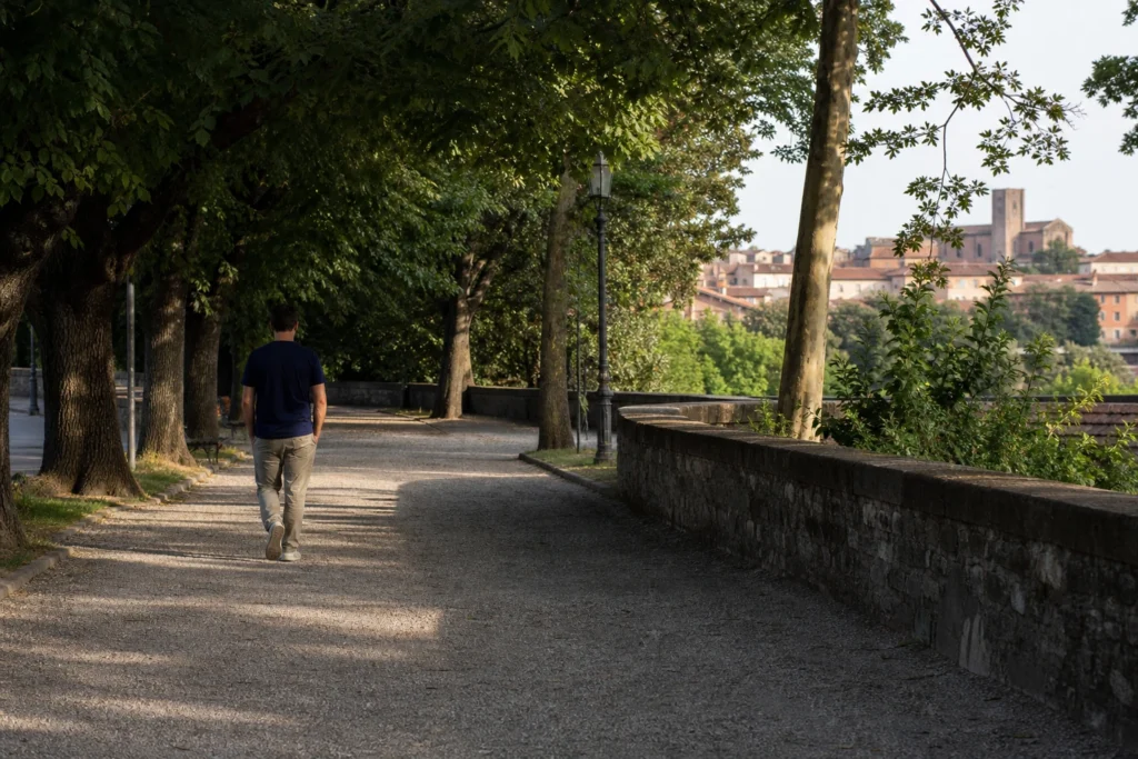 Persona che cammina serenamente in un parco come simbolo di indipendenza emotiva